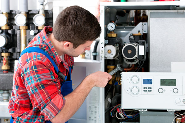 Heating technician repairing boiler controls in Los Gatos