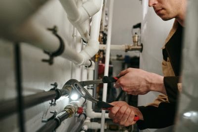 Technician inspecting commercial plumbing pipes in Los Gatos