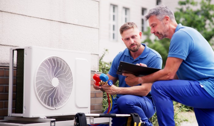 HVAC technicians installing an outdoor air conditioning unit in Los Gatos